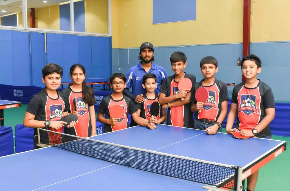 Tennis player serving the ball on a clay court during sunset
